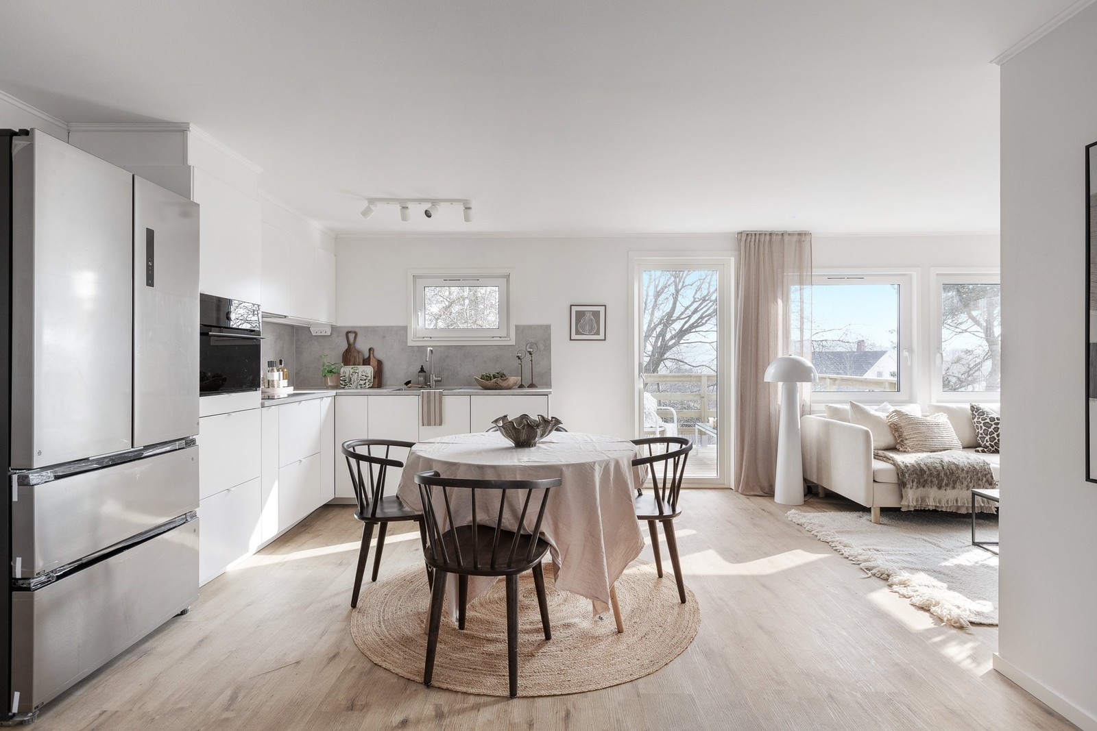 Öppen planlösning mellan kök och vardagsrum med utgång till altan