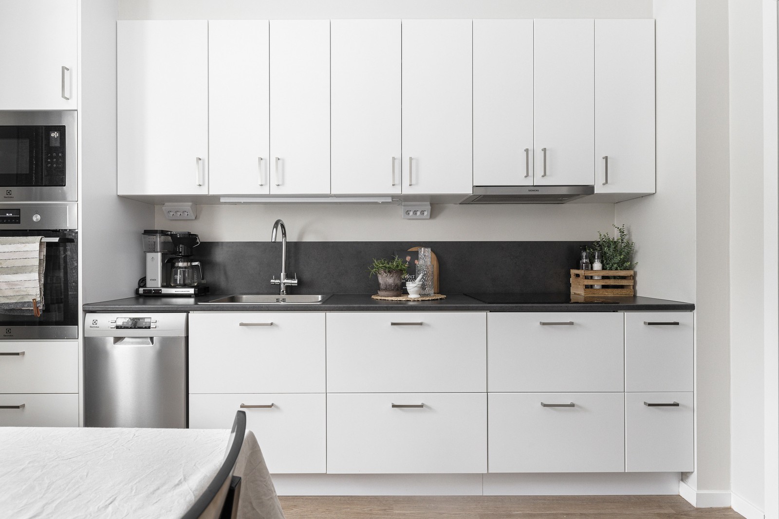 Ett stilrent och ljust kök som erbjuder en inbjudande och modern atmosfär