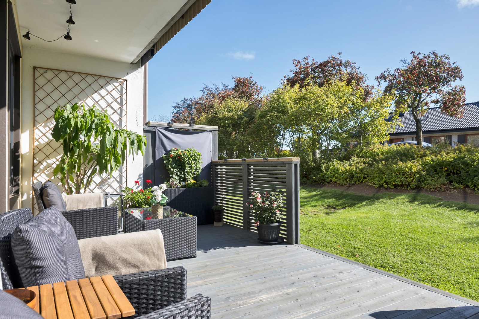 Bostadens uteplats blir en naturlig förlängning av hemmet med grönskan alldeles utanför.
