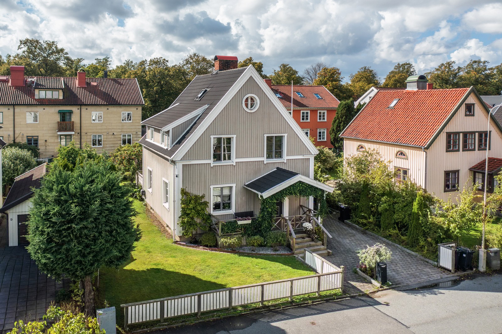 Charmigt trähus med grönskande trädgård i ett lugnt villakvarter