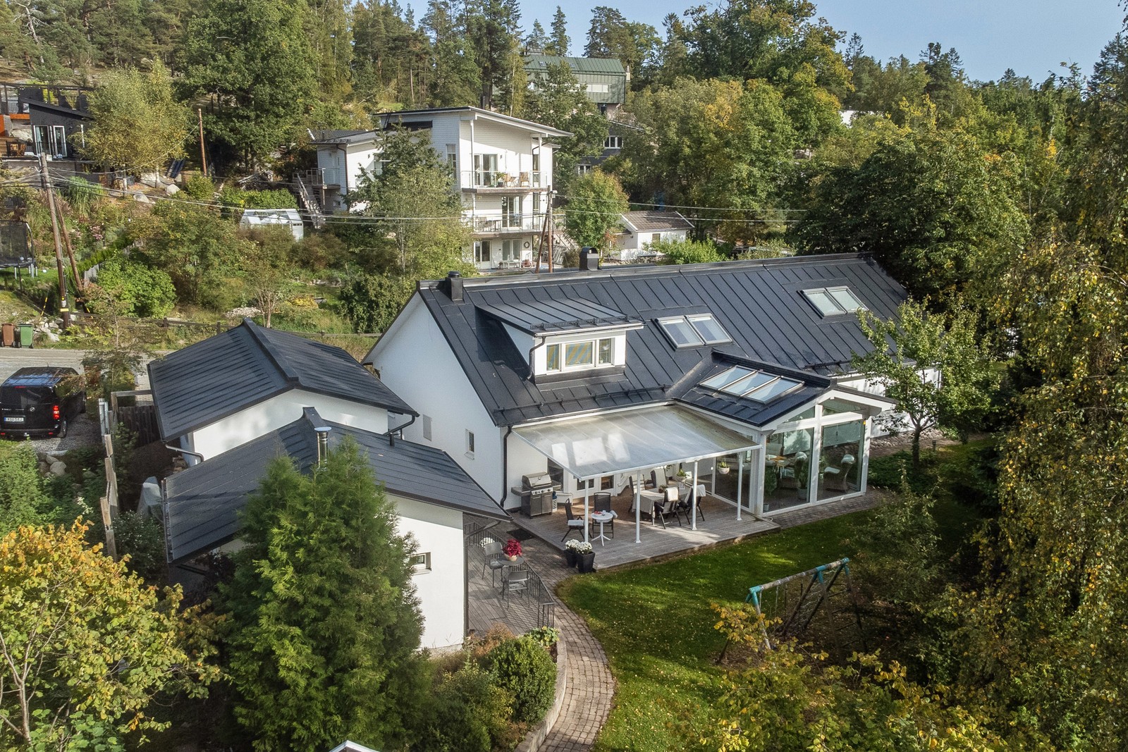 Fastigheten med vitputsade stenhus fint inbäddad i grönska och belägen nära havet