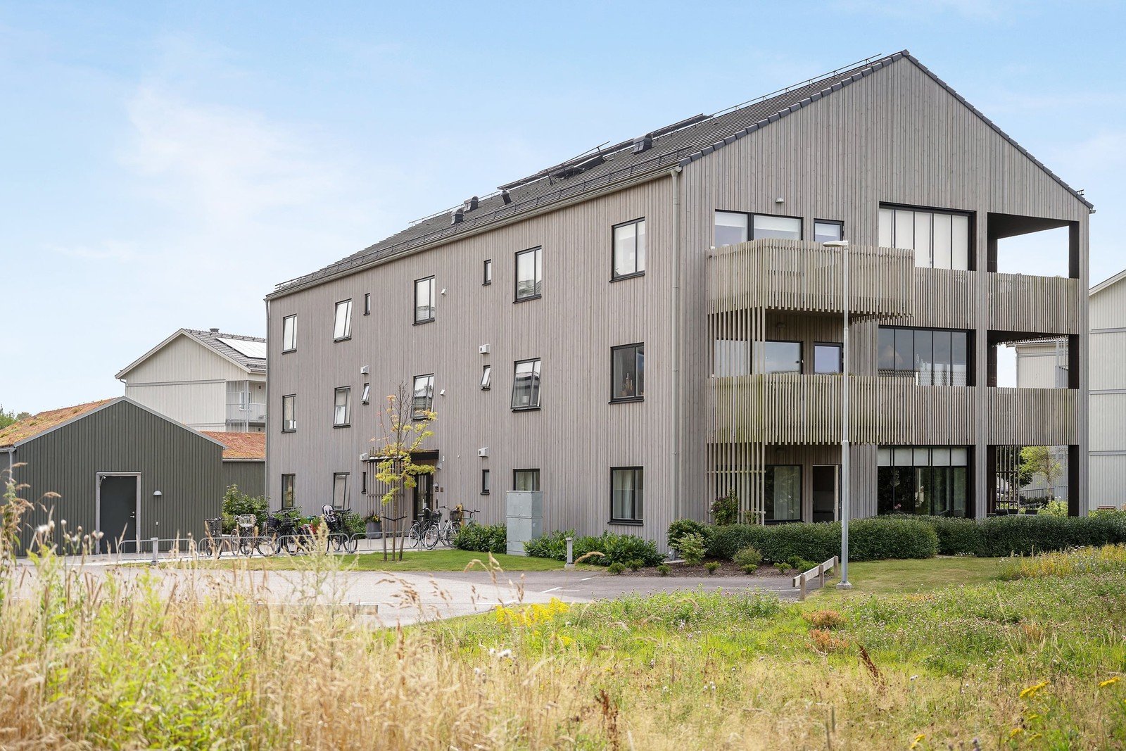 Bostaden är belägen på husets bottenplan med uteplats och grönska utanför.