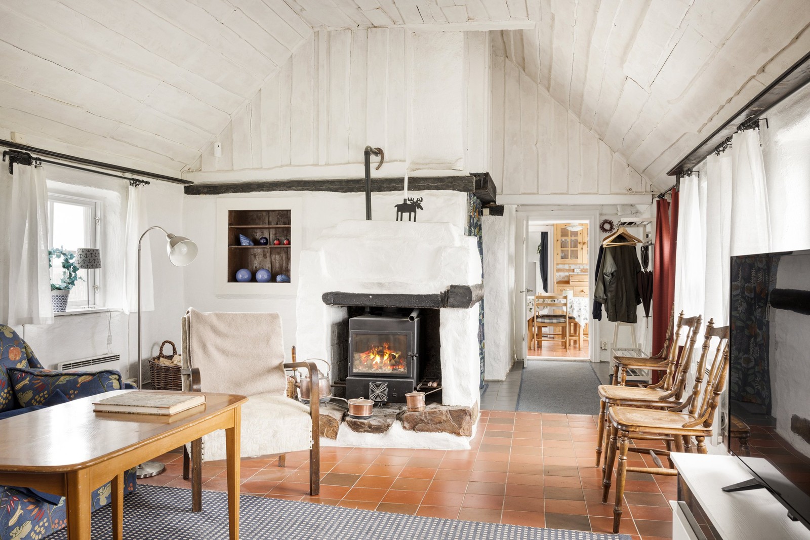 Allrum med öppen planlösning och vacker och värmande braskamin.