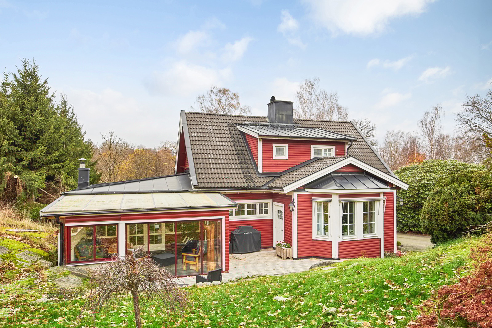 Ett inglasat uterum med en insynsskyddad uteplats med dörr mot köket