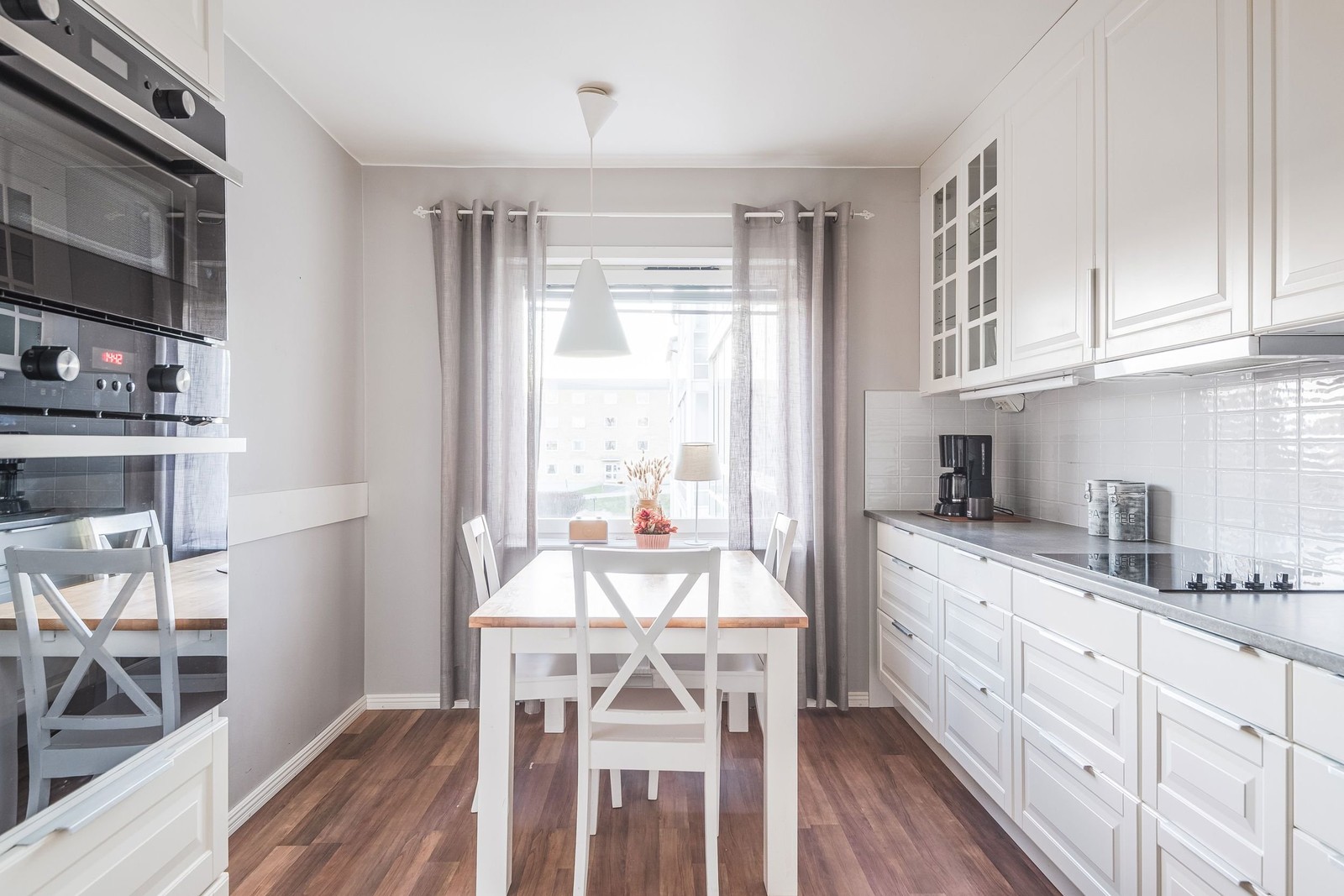 Kök med plats för matbord vid fönster.