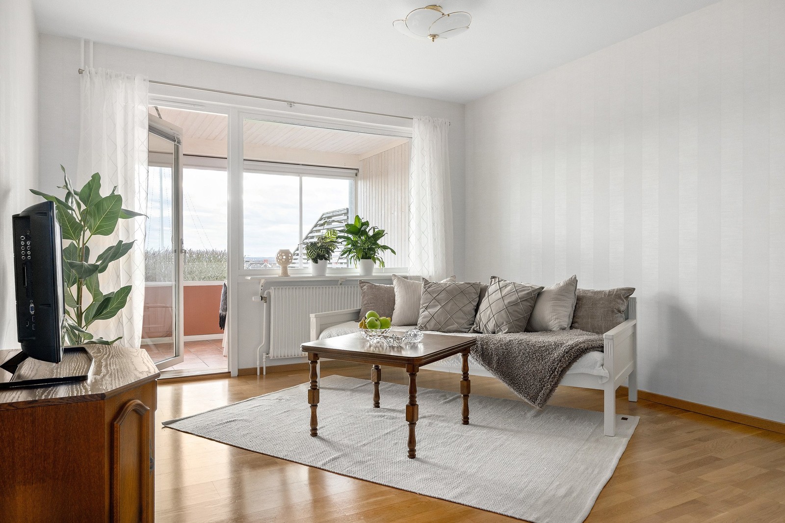 Från vardagsrummet nås det inglasade uterummet som blir en naturlig förlängning av bostaden.