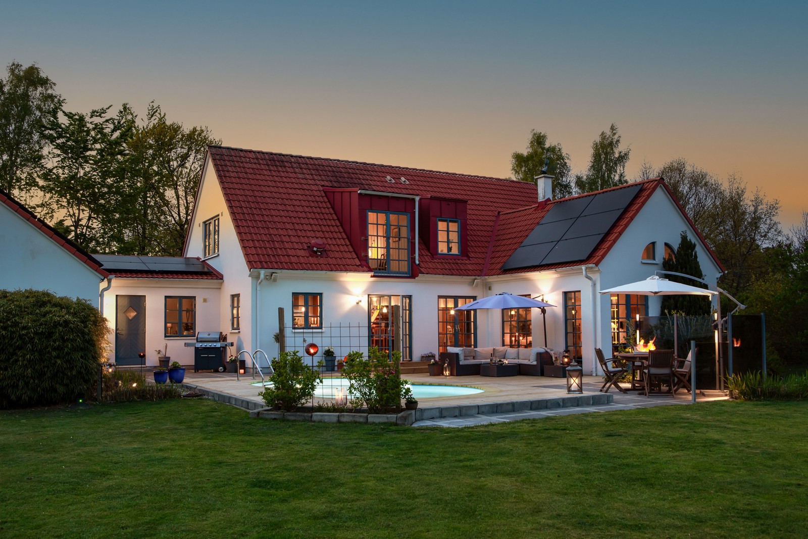 Skymningsbild mot huset och poolen