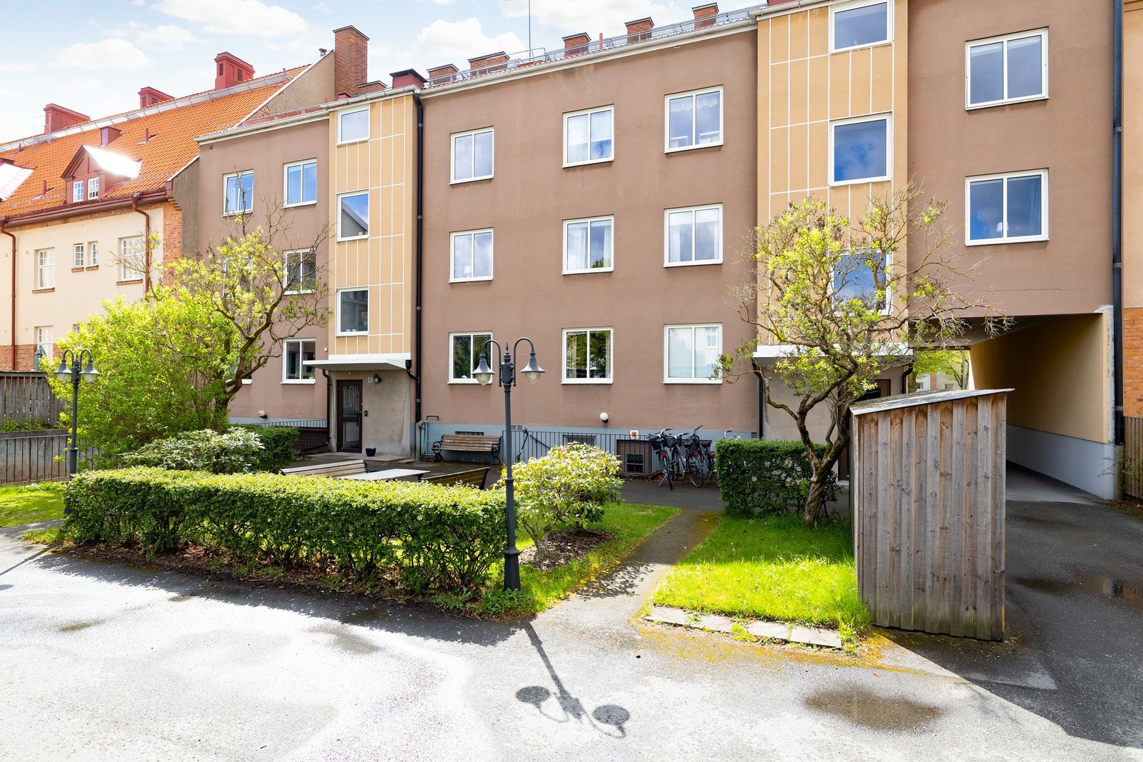 Inhägnad innergård med både parkeringar och uteplats.