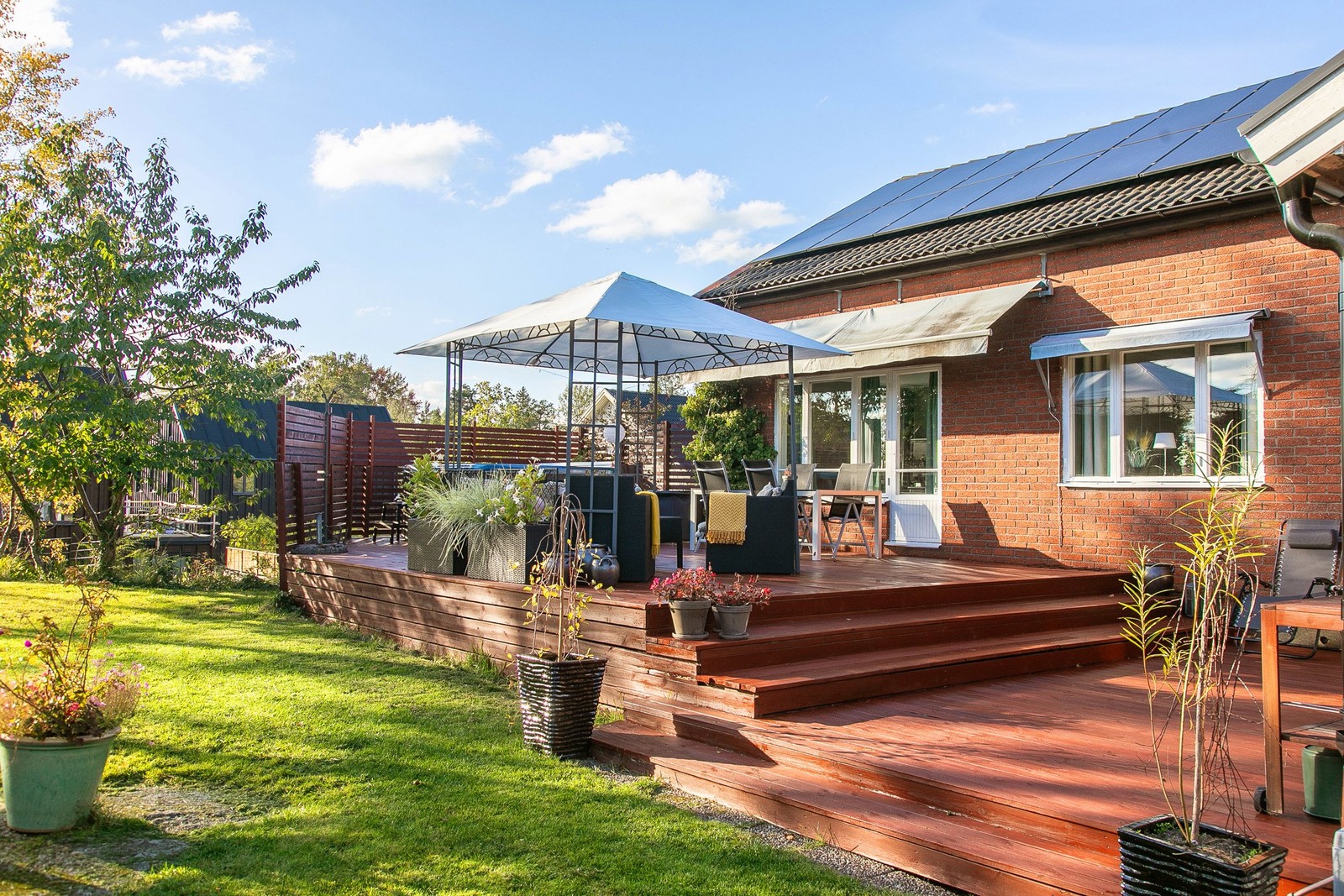 Detta hus har plana gräsytor och mysiga soliga uteplatser