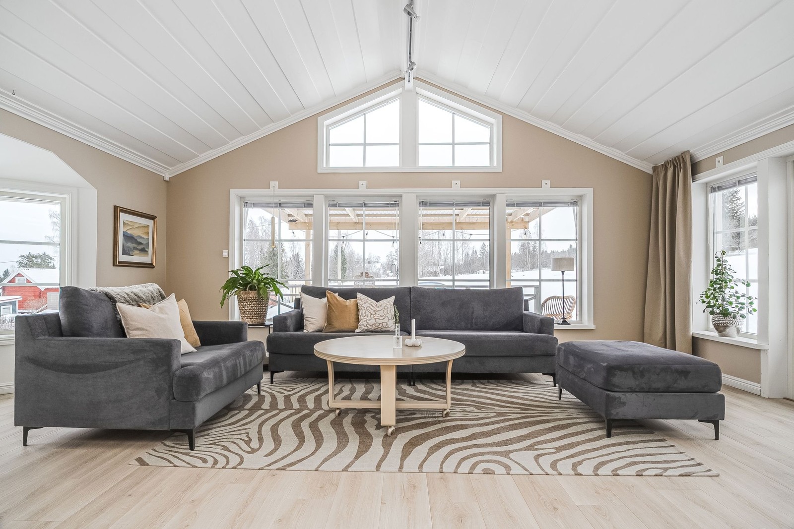 Rymligt vardagsrum med ryggåstak och stora fönsterpartier som ger fint ljusinsläpp.