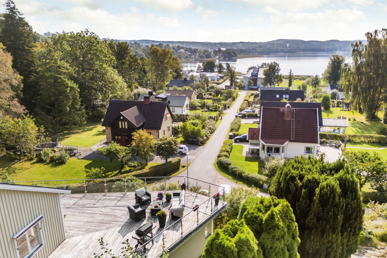 Vy över Aspenäs och sjön Aspen med husets uteplats i förgrunden