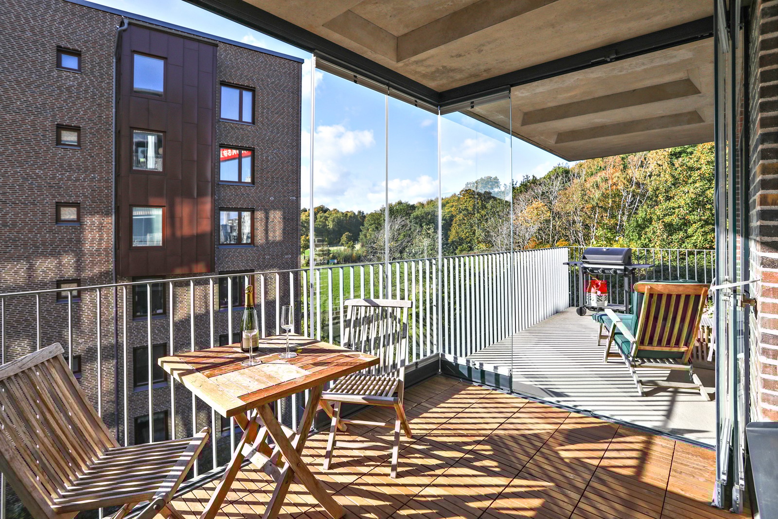 Stor solig balkong som är delvis inglasad