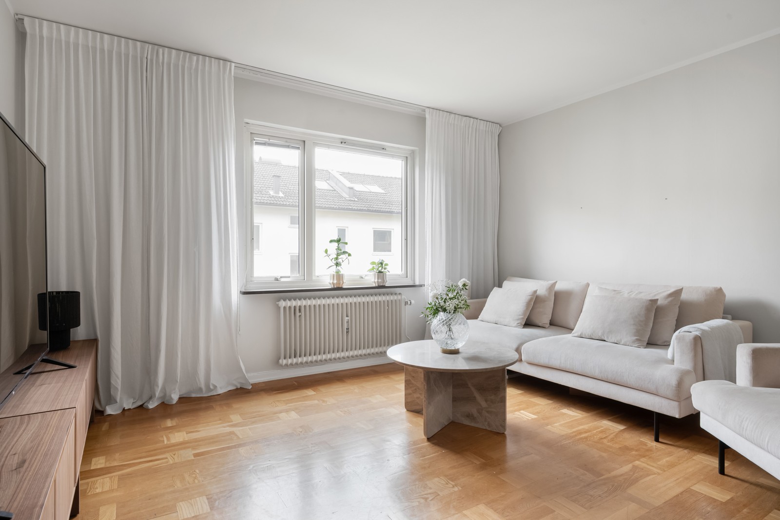 Öppet och ljust vardagsrum med generös takhöjd.