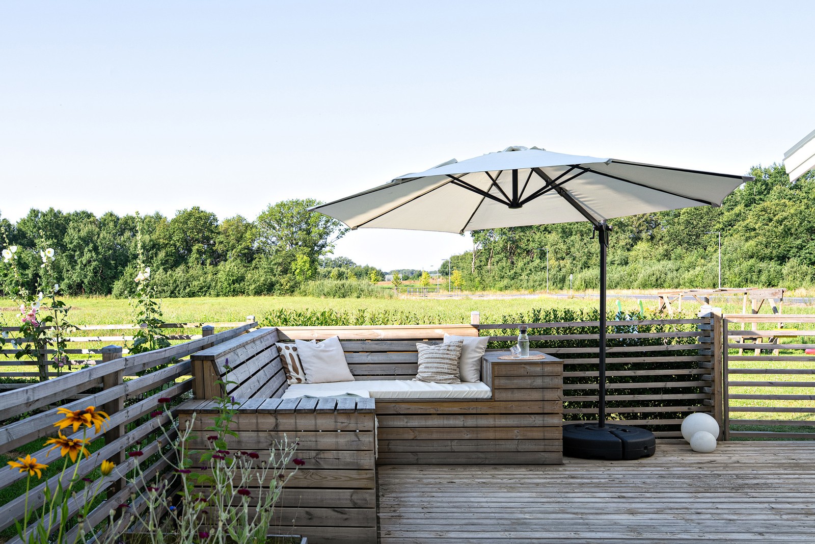 Stort trädäck mot öppna ängar