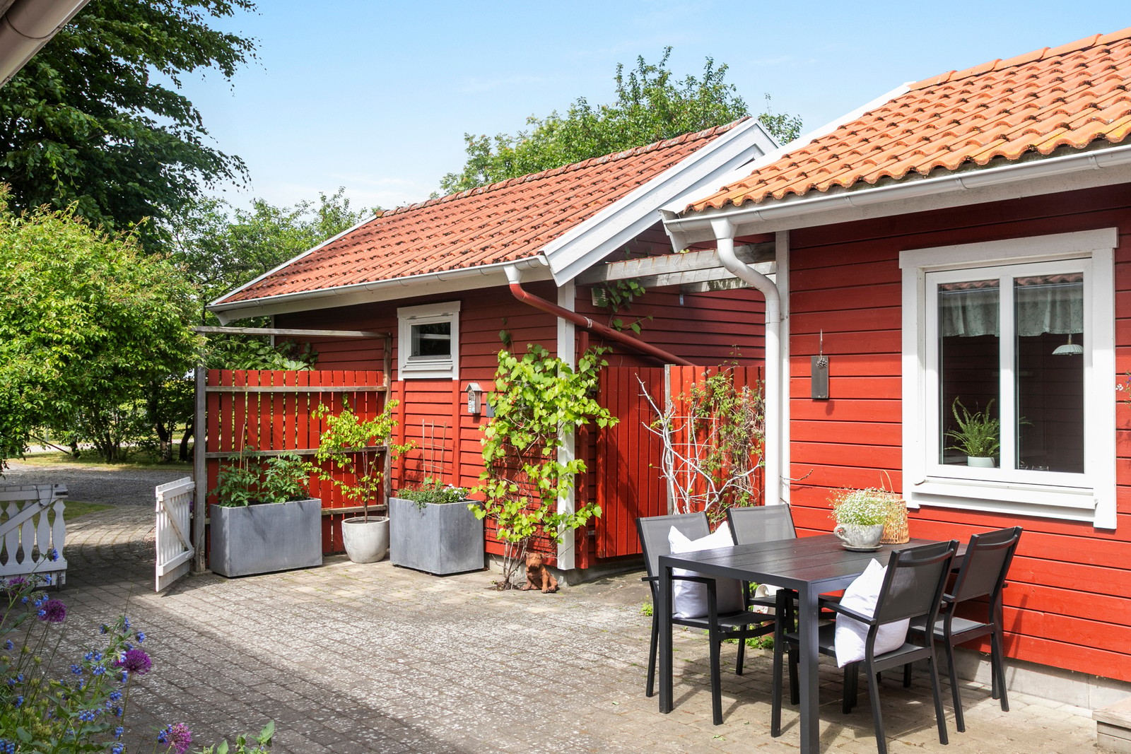 På bilden syns garaget till vänster och attefallshuset till höger.