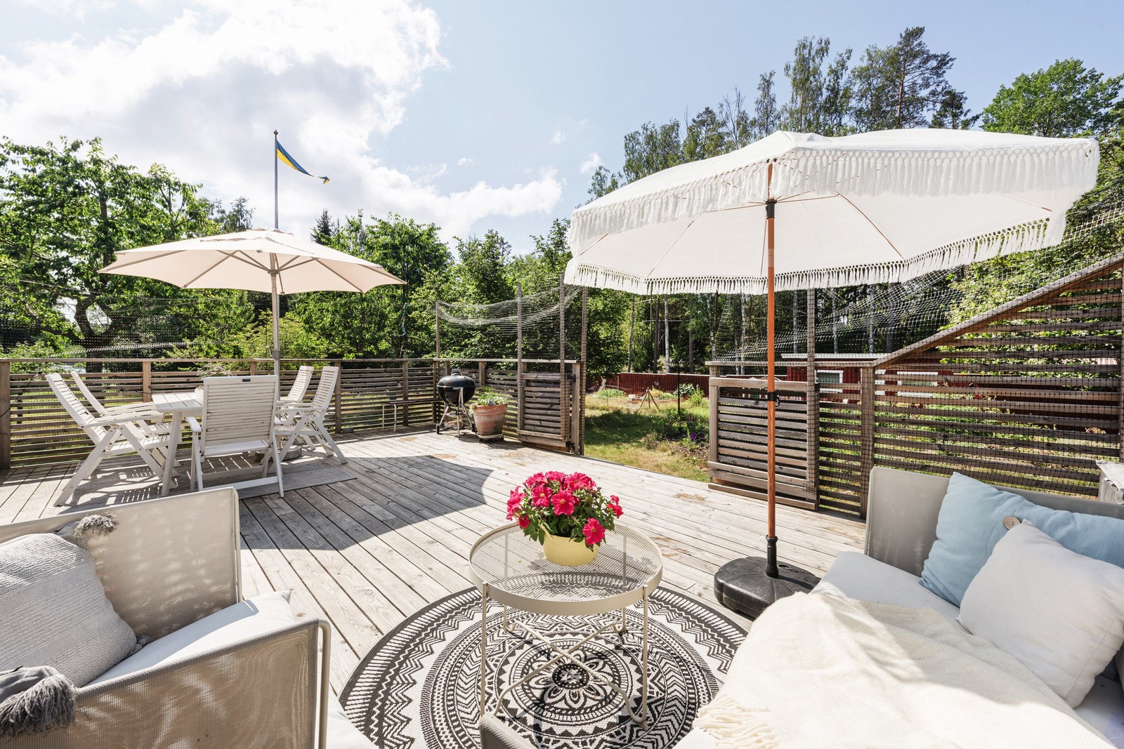 Stor och solig altan med generös yta för både loungemöbler och matgrupp.