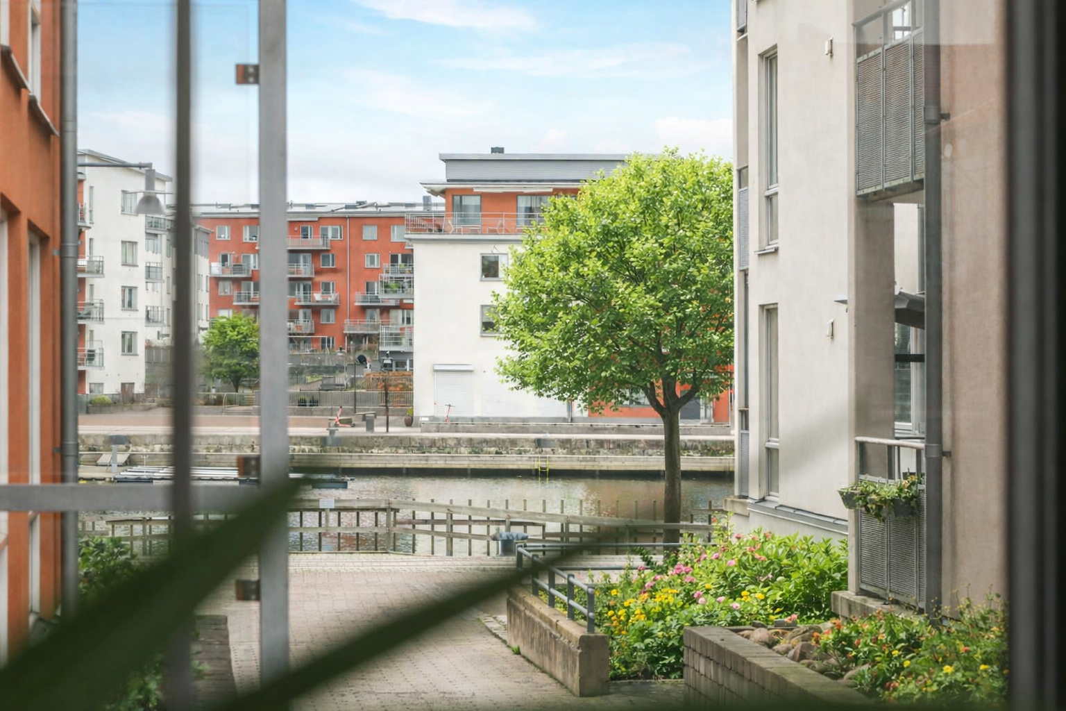 Balkong med vy mot vattnet (löven på träden är AI-genererade)