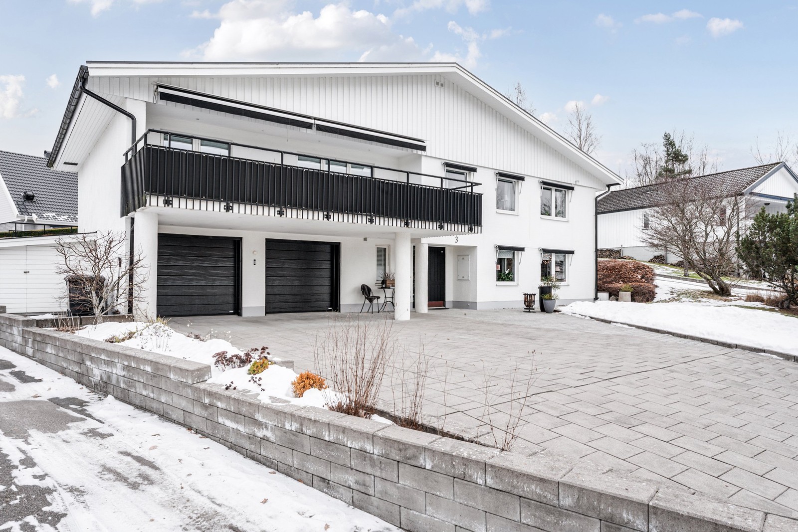 Stor stenlagd infart med dubbelgarage i huskroppen