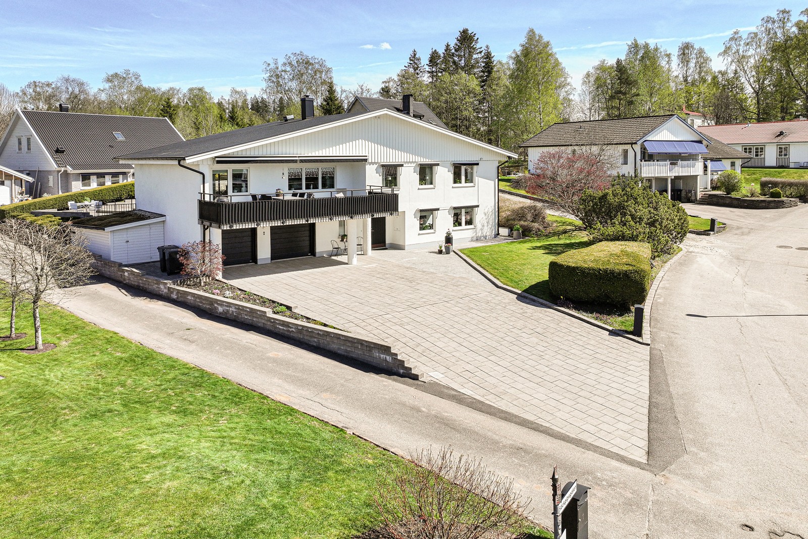 Stor stenlagd infart med dubbelgarage i huskroppen
