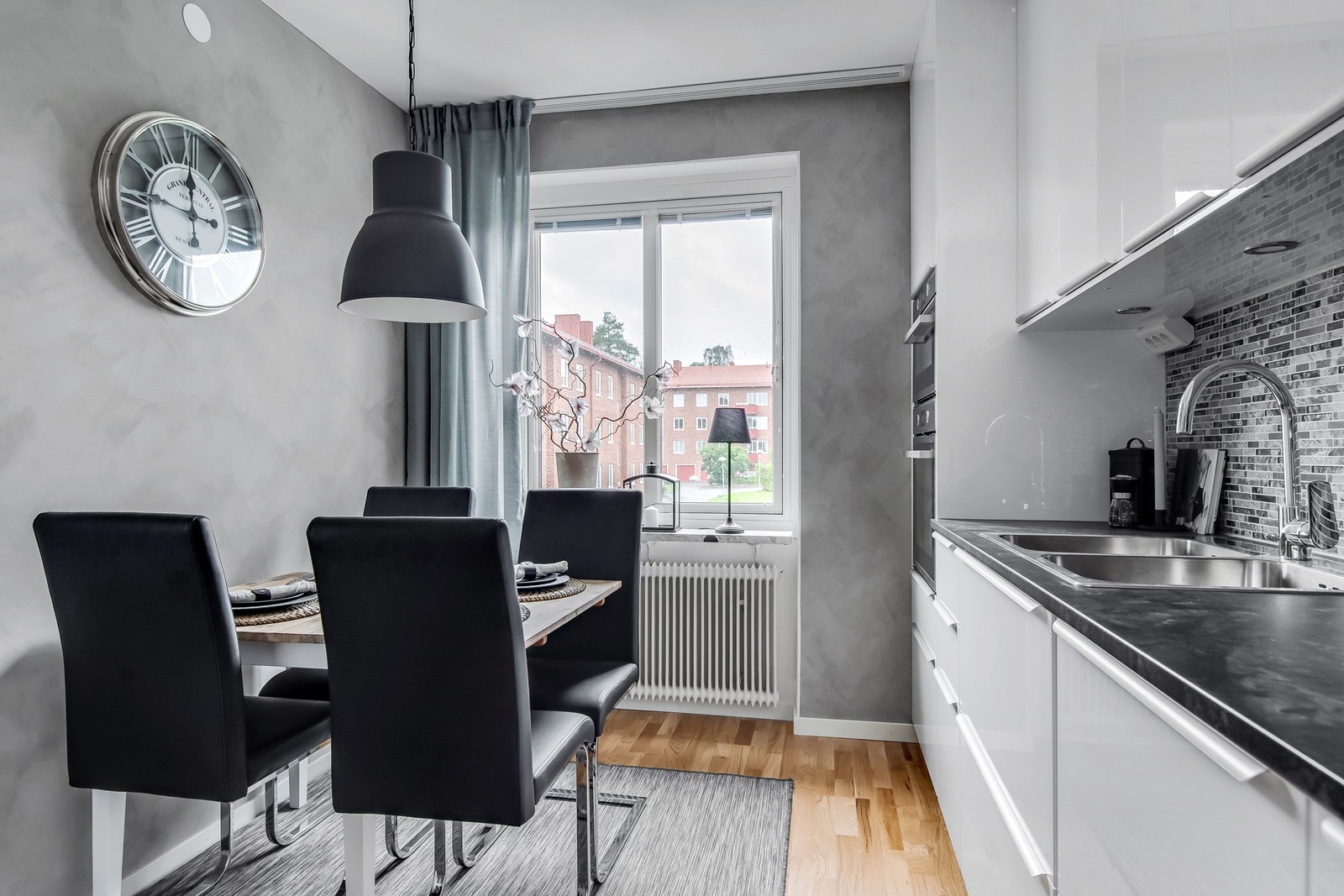 Nyrenoverat kök med plats för matbord vid fönster.