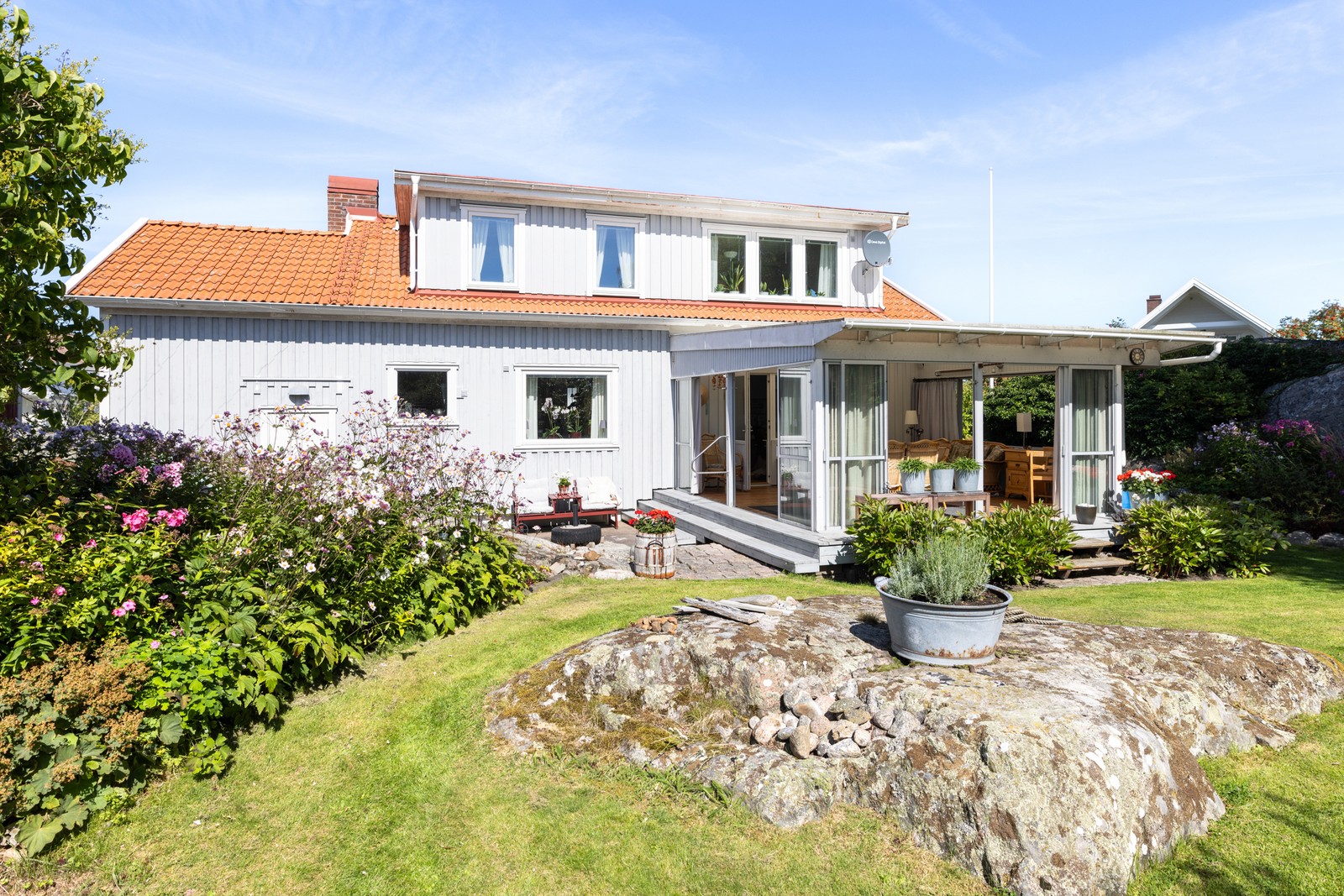 Fastigheten med vackert uppvuxen trädgård och uterum