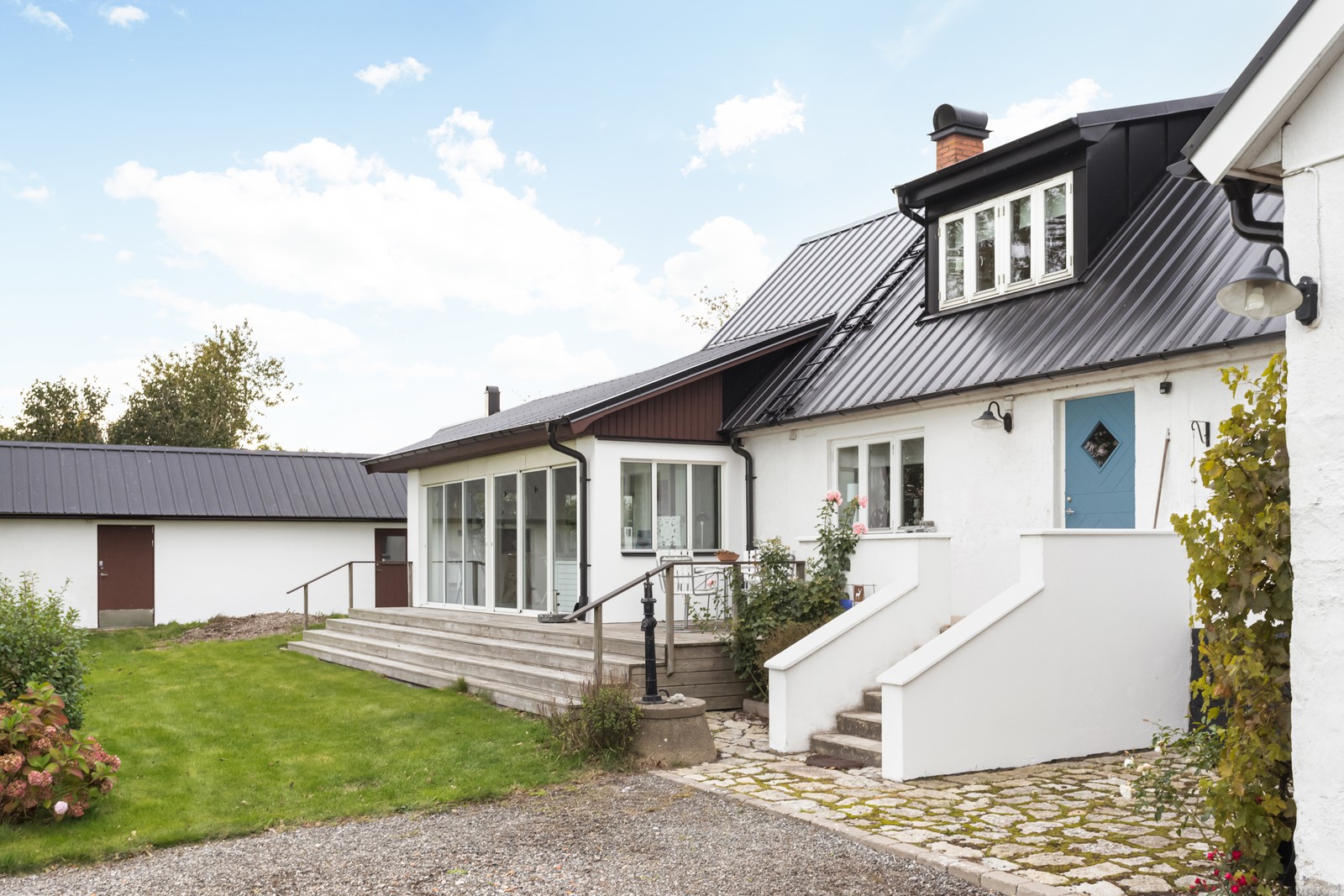 Entrésidan och länga med förråd i bakgrunden