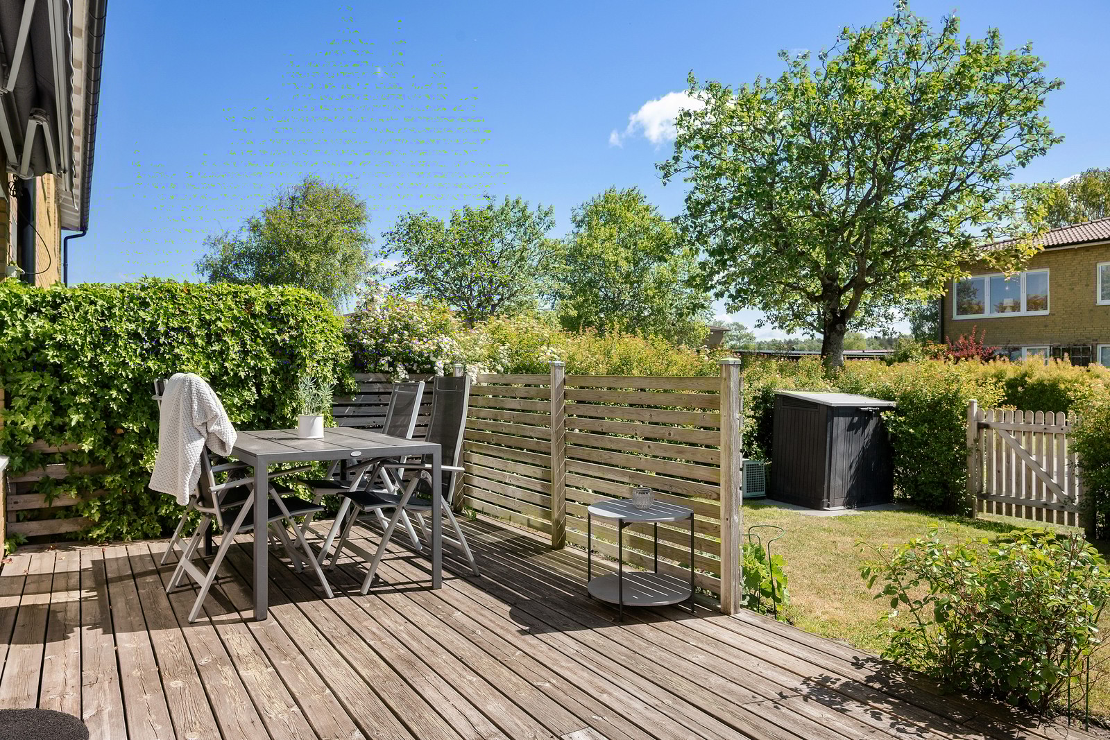 Lummig och privat baksida med altan och gräsmatta – en underbar plats för sommarens alla stunder.