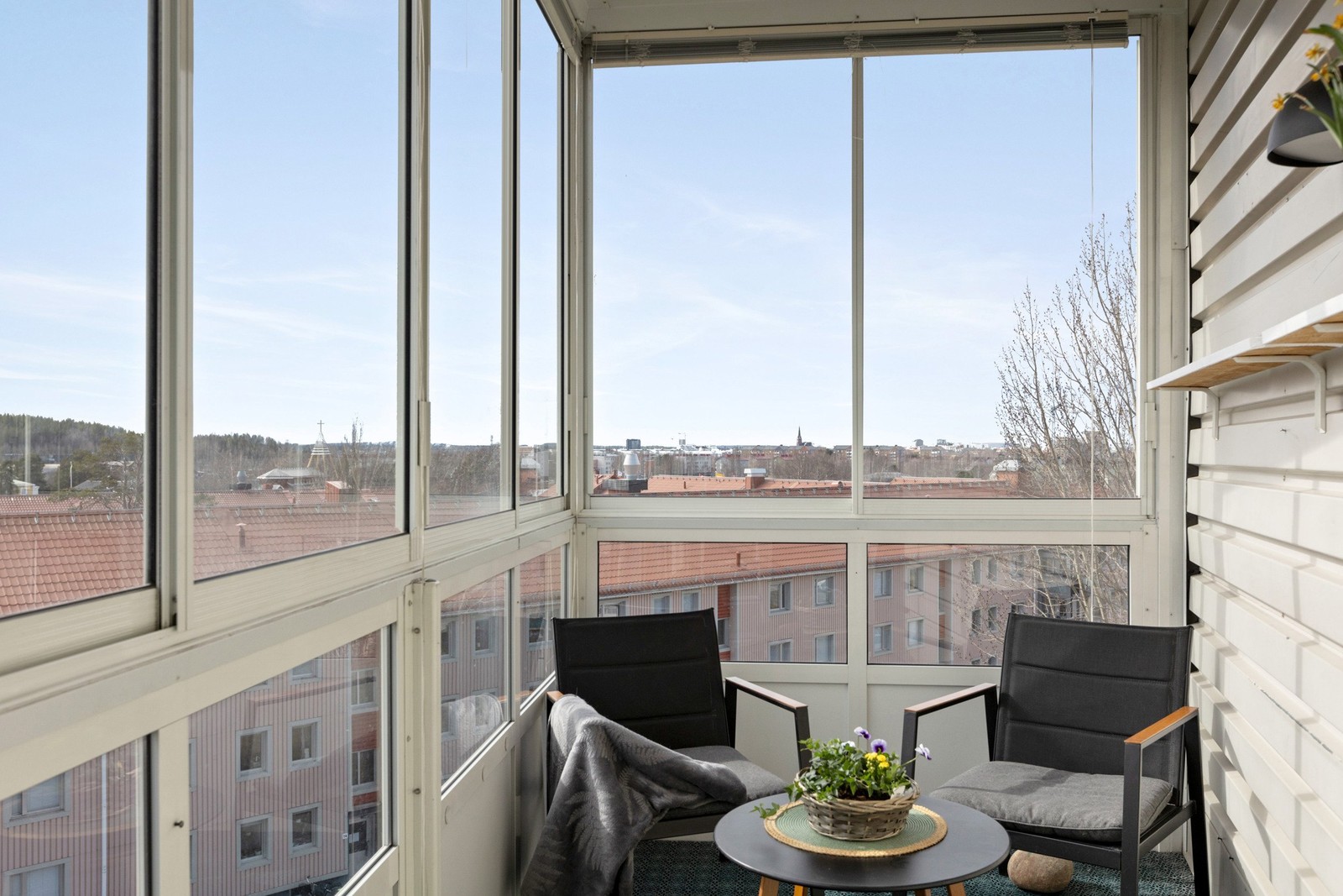 Inglasad balkong med vy mot staden