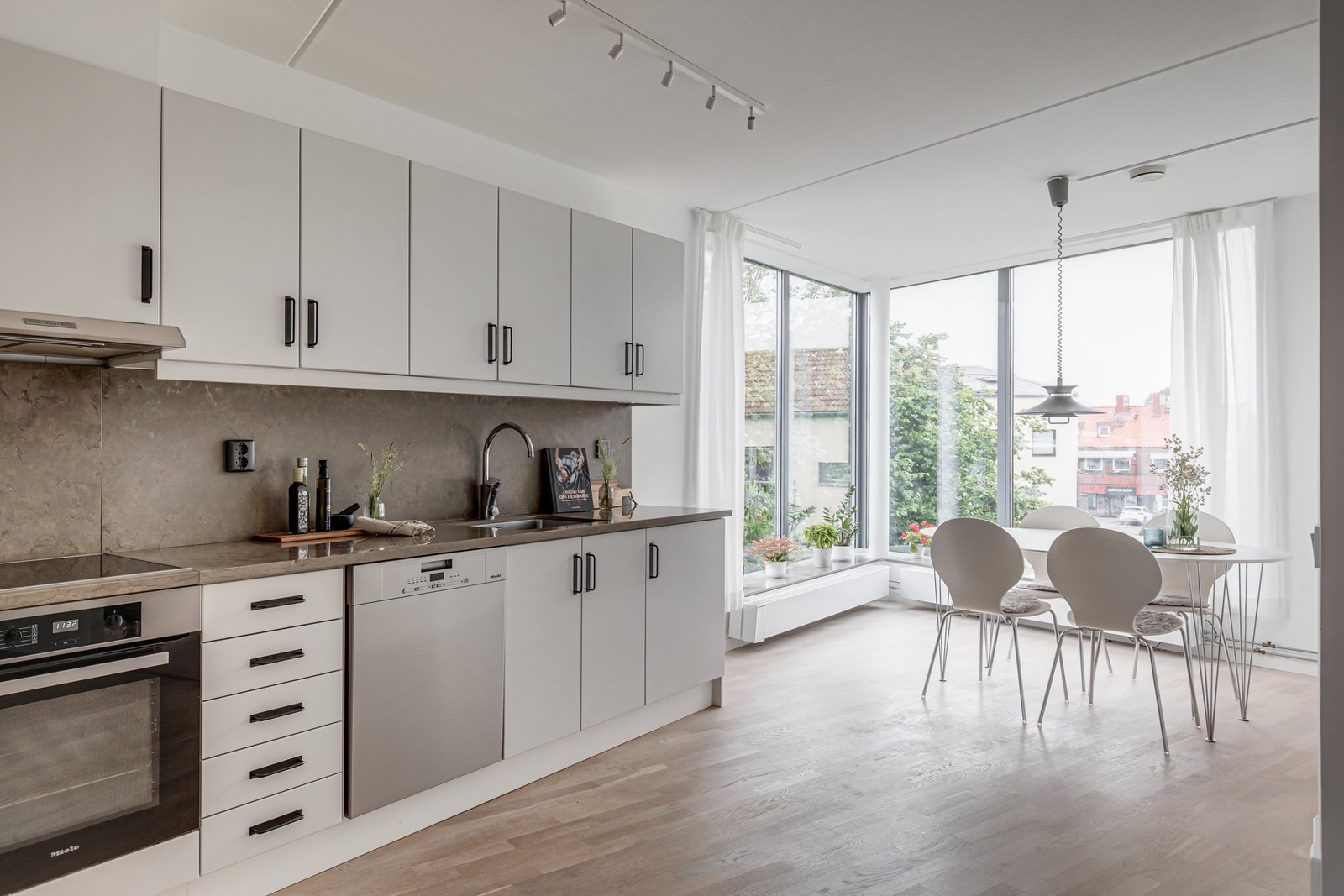 Smakfullt renoverat kök med matplats med fönster från golv till tak
