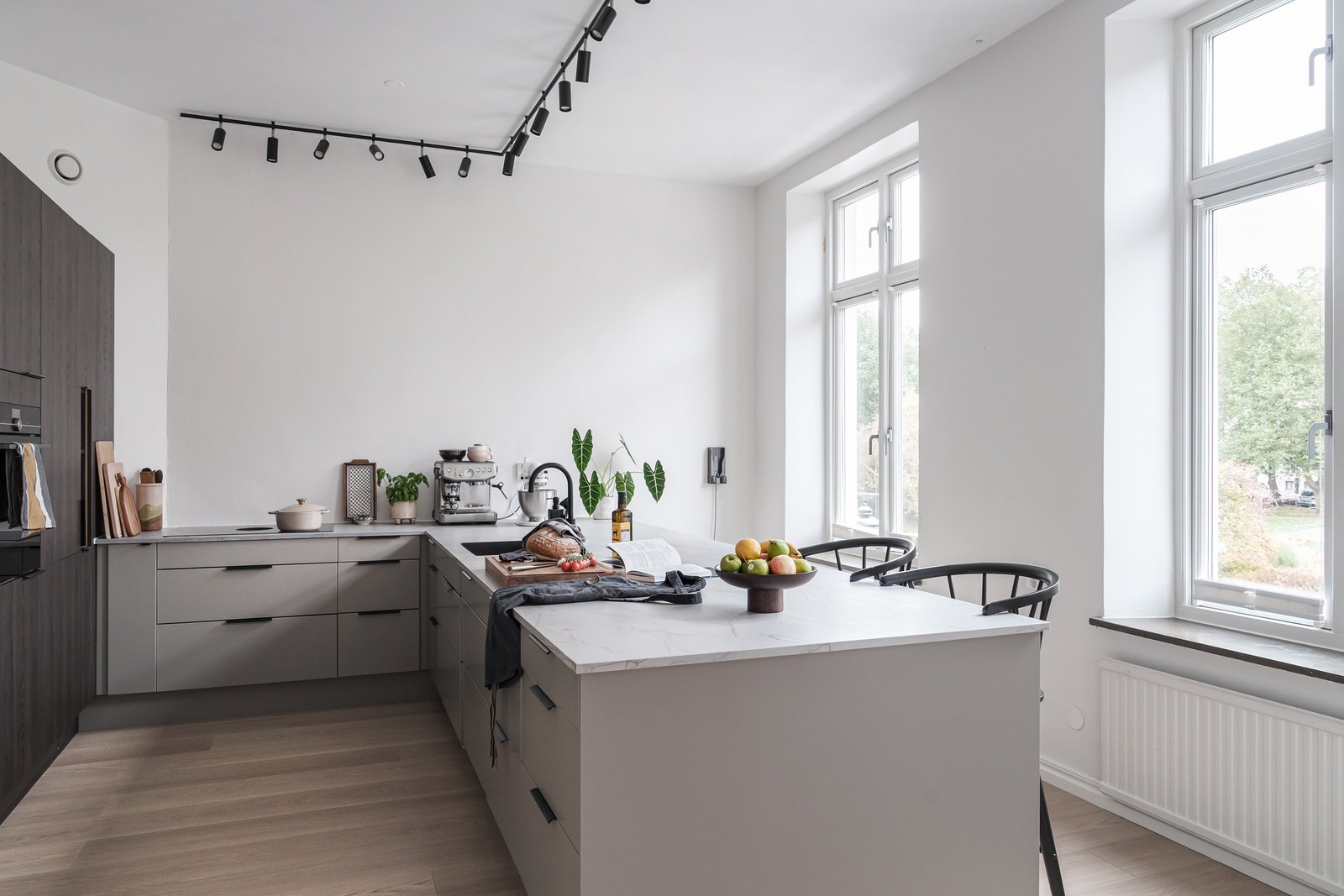 Köket är både rymligt och stilfullt med mörka träluckor och en generös köksö.