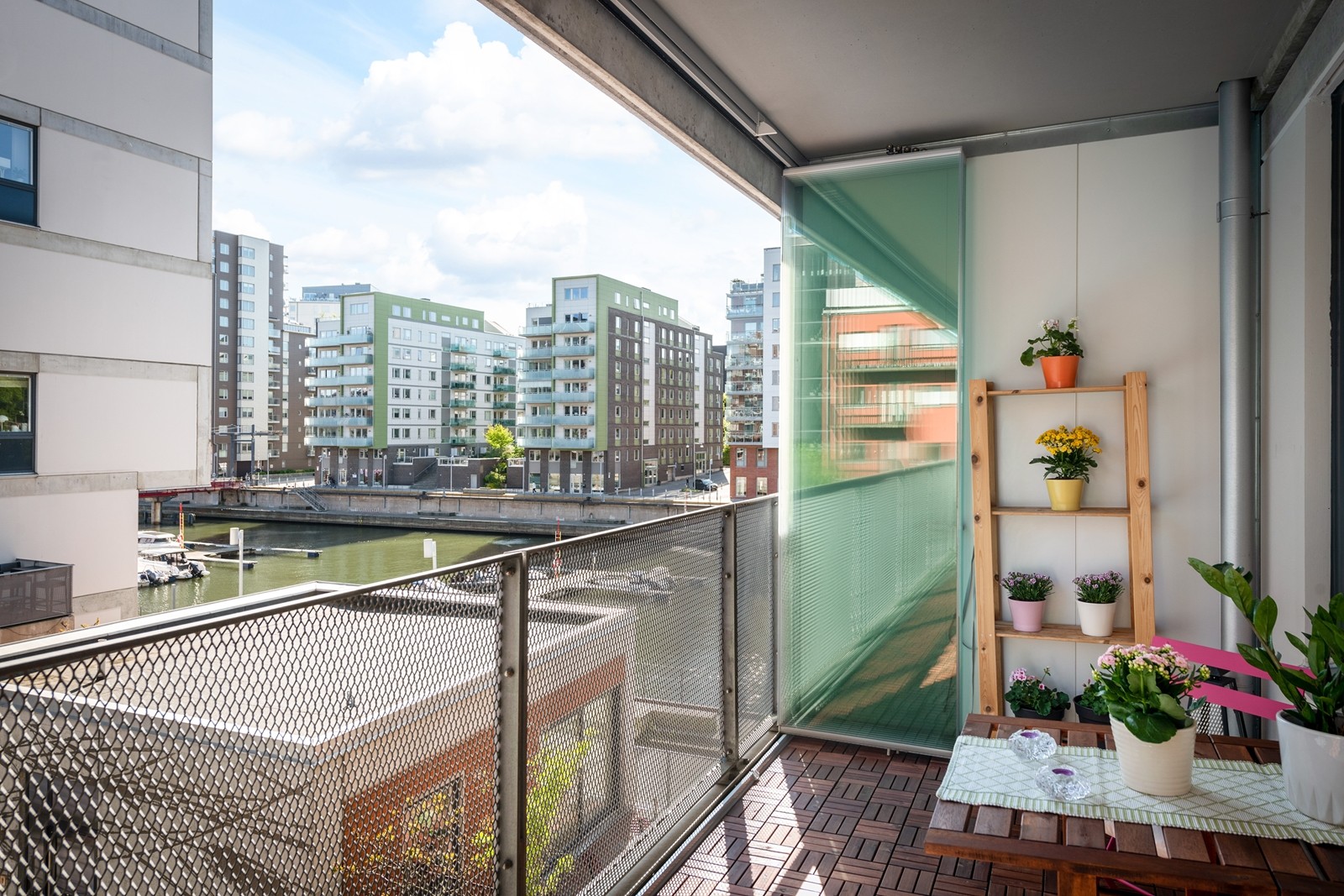 Stor inglasad balkong med utsikt mot vattnet och föreningens poolområde