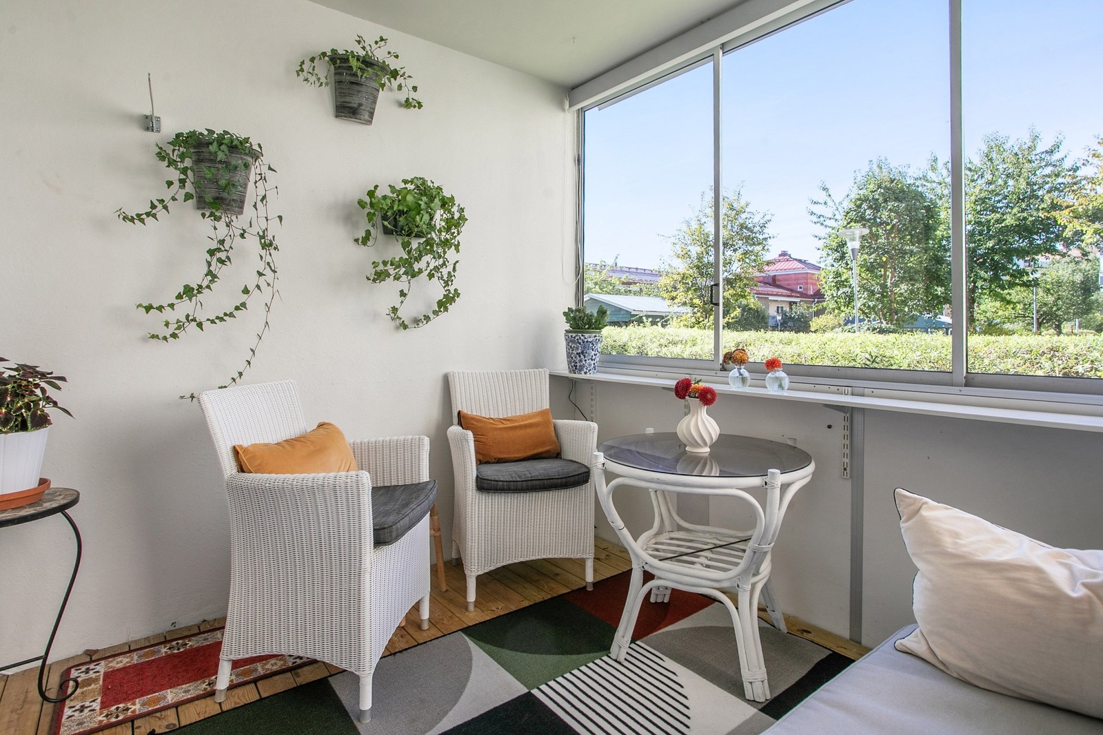 Härlig uteplats i form av en inglasad balkong inramad av grönskan utanför