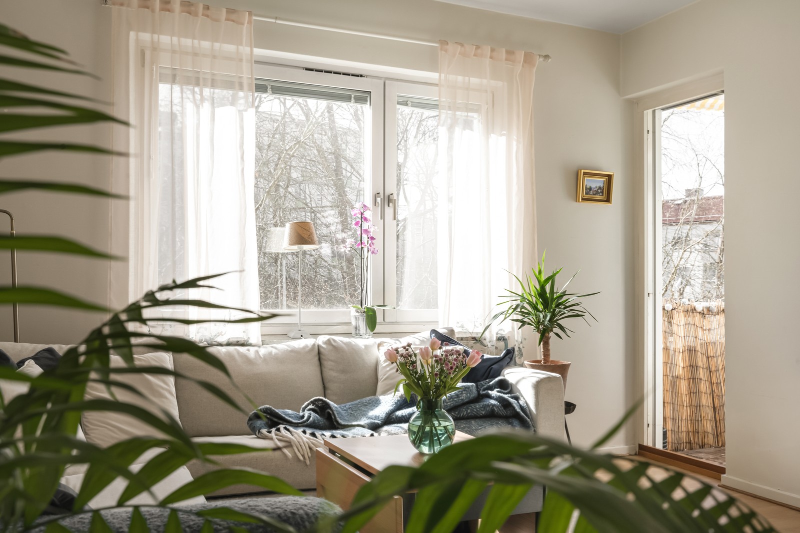 I vardagsrummet sipprar ljuset in genom såväl fönster som genom balkongdörren