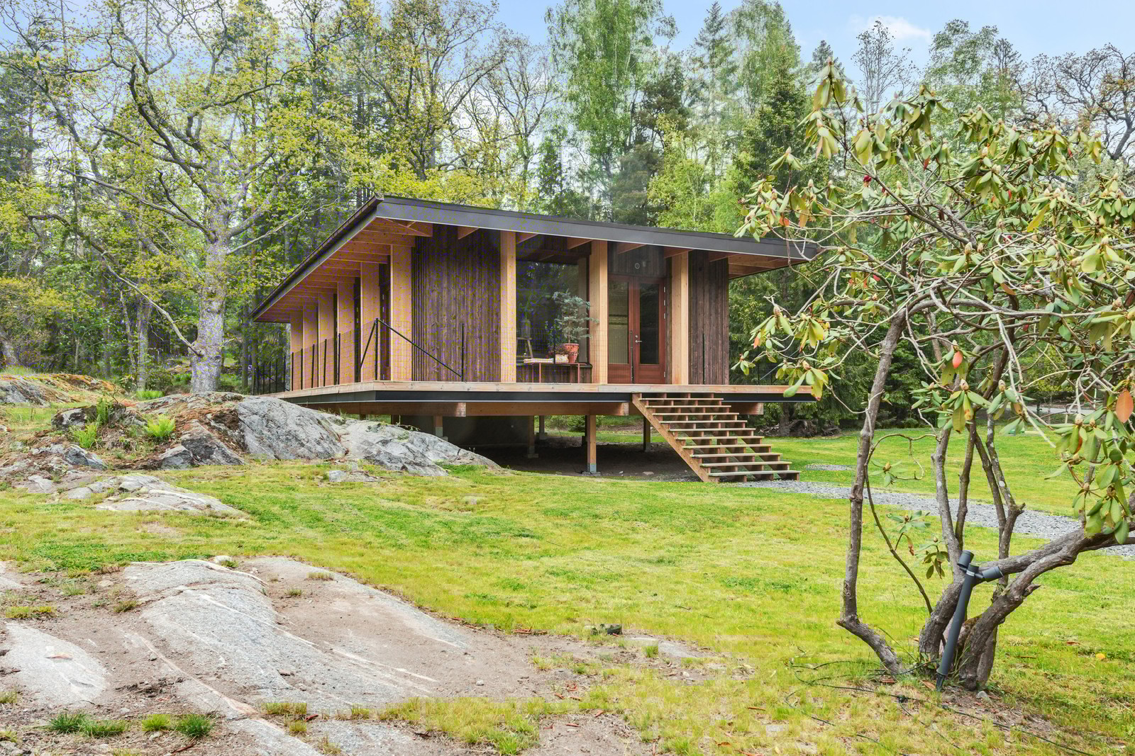 Inbäddad i grönska ligger detta stilrena enplanshus