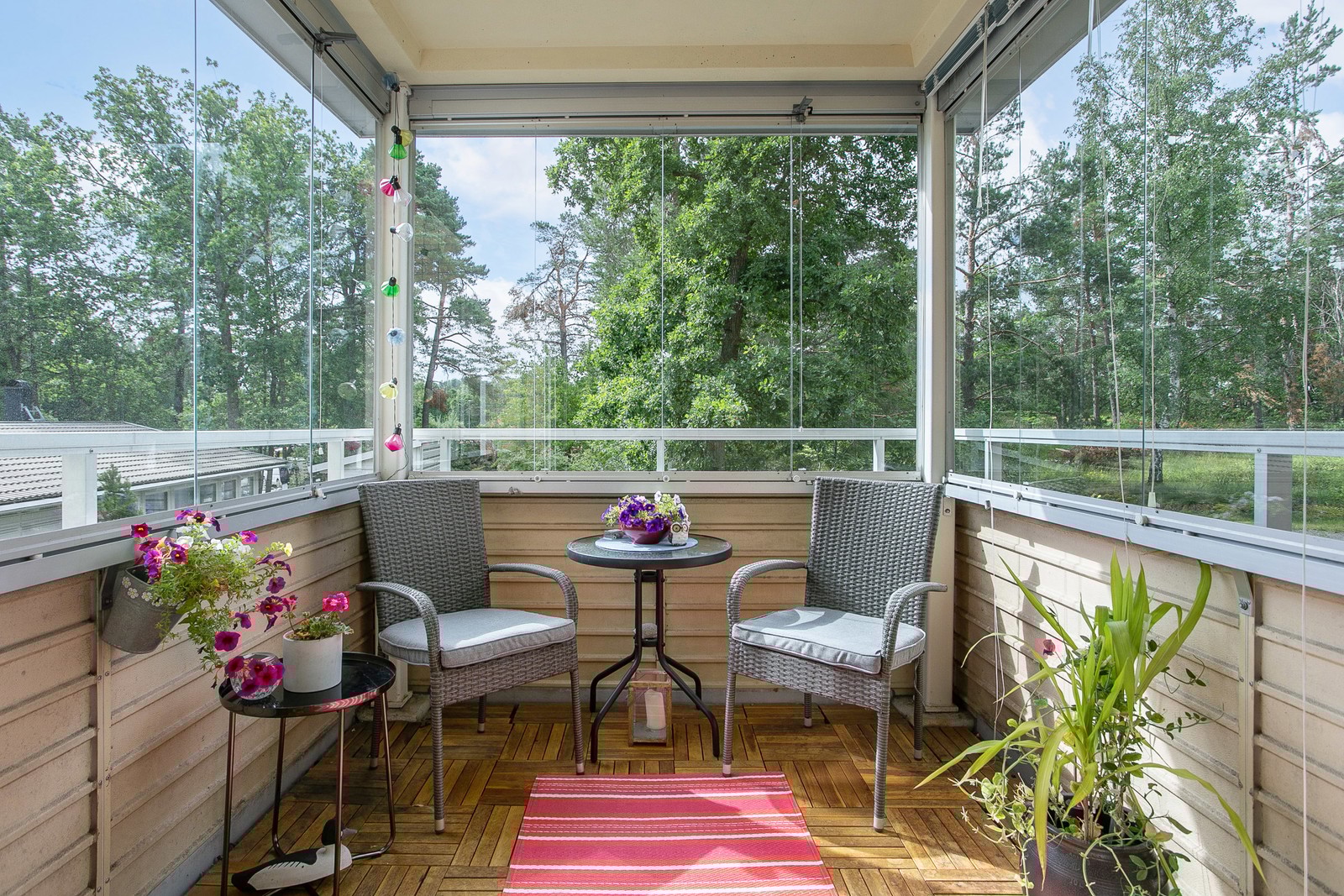 Solig inglasad balkong mot grönska