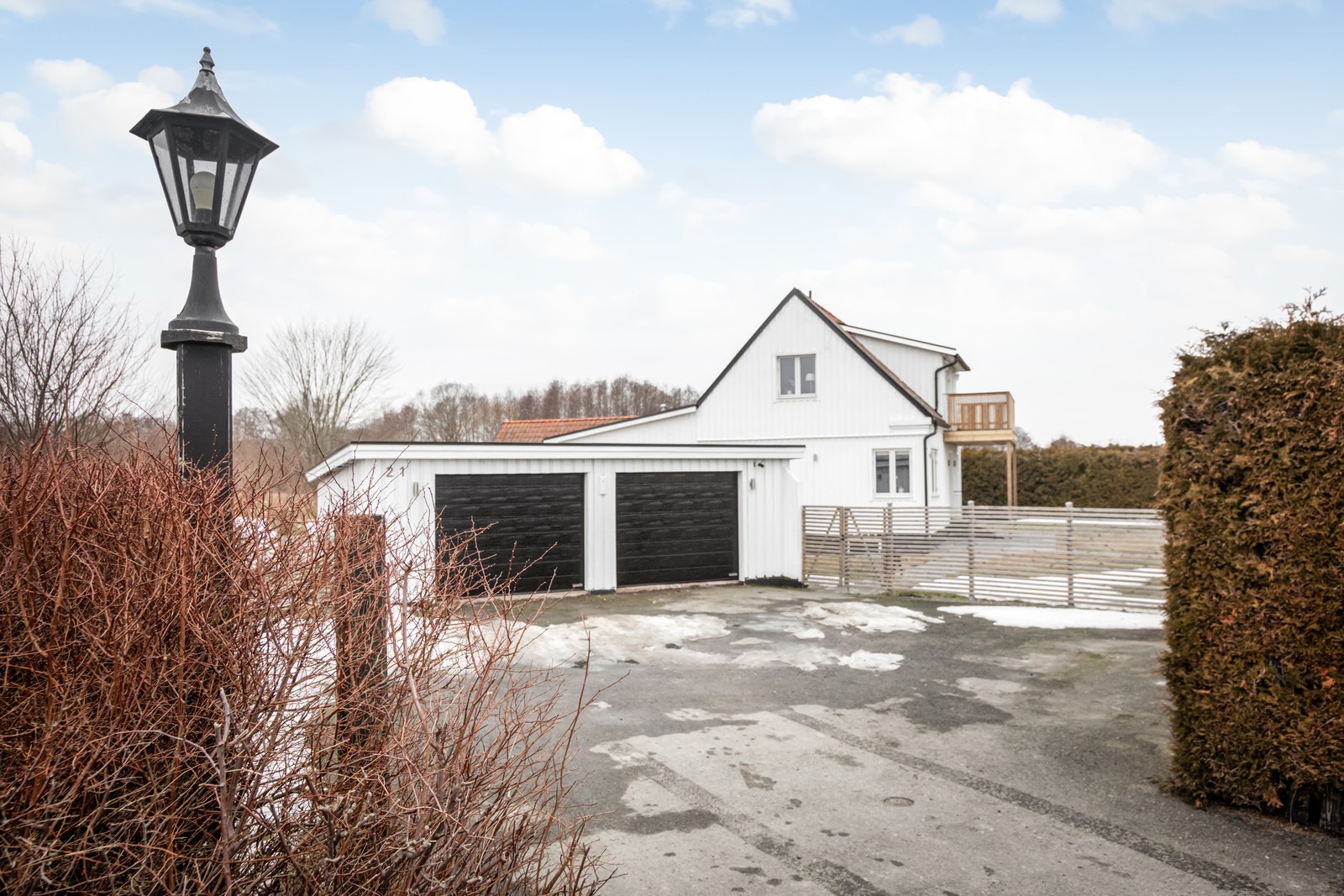 Stor uppfart samt dubbelgarage, sett mot bostad