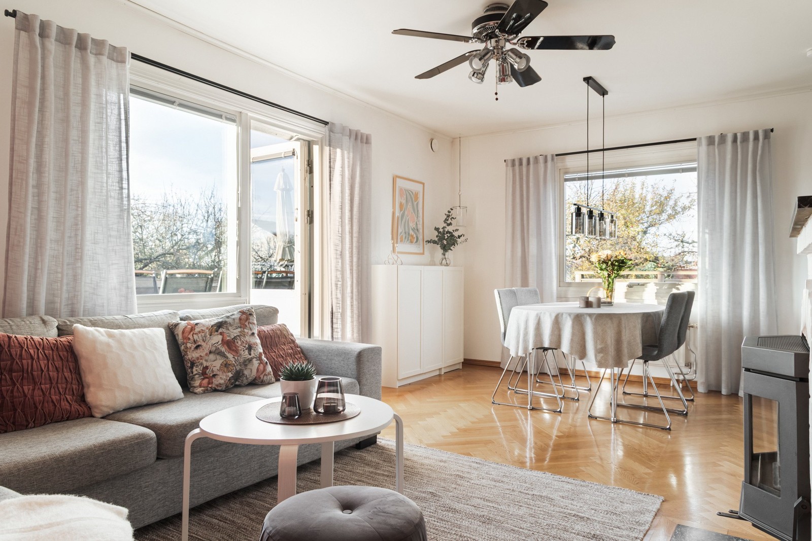 Ljuset flödar in genom de stora fönsterpartierna i vardagsrummet