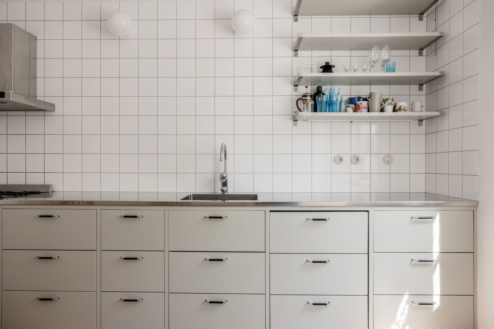 Shaker-kök med öppna hyllplan och väggbelysning ger det lilla extra