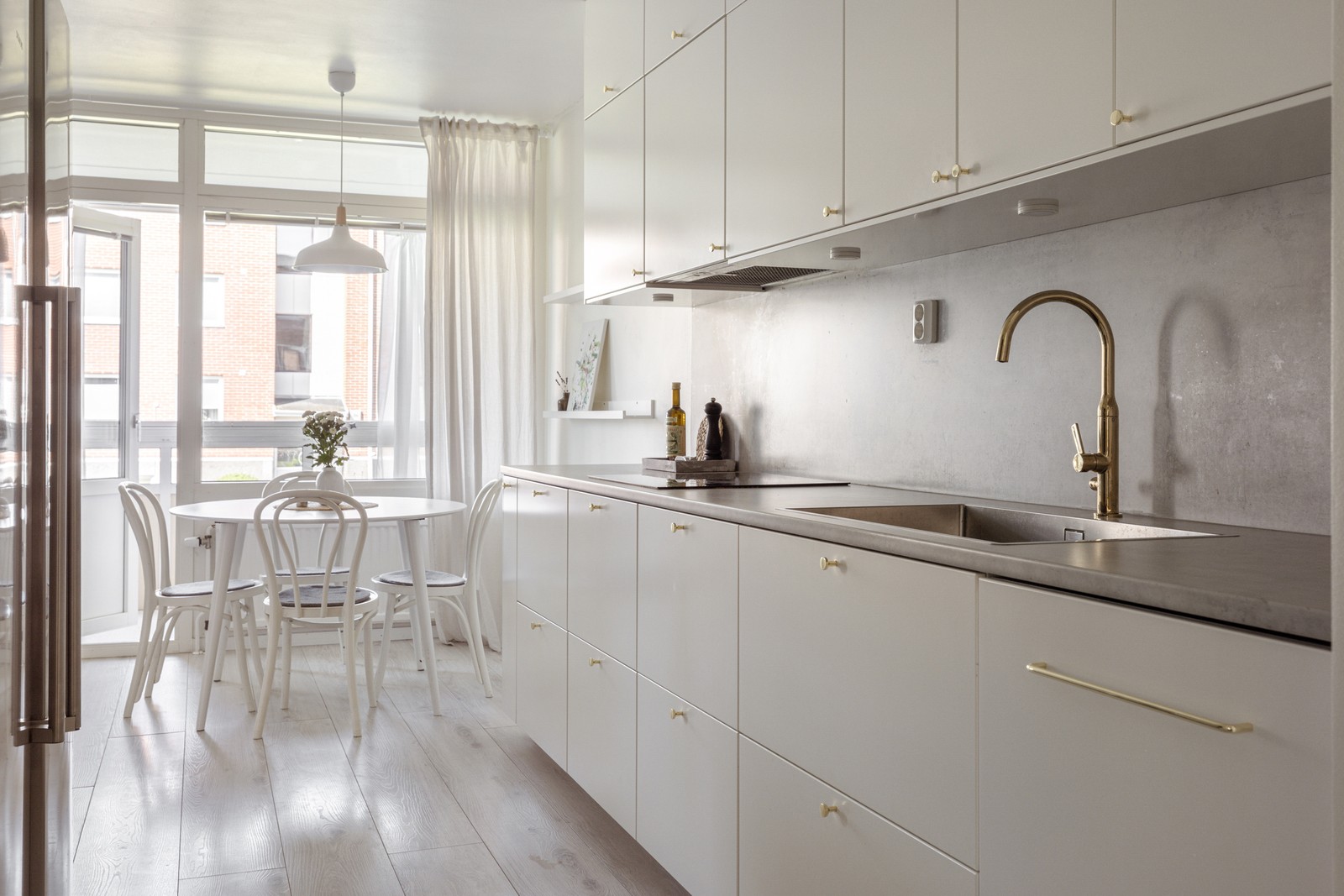 Stilrent, renoverat vitt kök med mässingsdetaljer