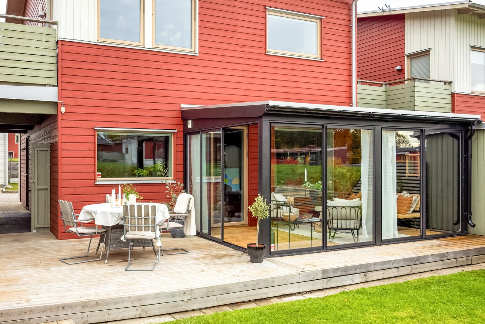 Solig baksida med altaner, uterum och härliga gräsytor