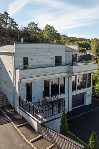 Den privata uppfarten klättrar upp till den nybyggda sluttningsvillan med en bruksarea på 562 kvm