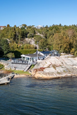 En tidlöst ljus havsvilla med sensationell havsutsikt ute på en egen klippudde
