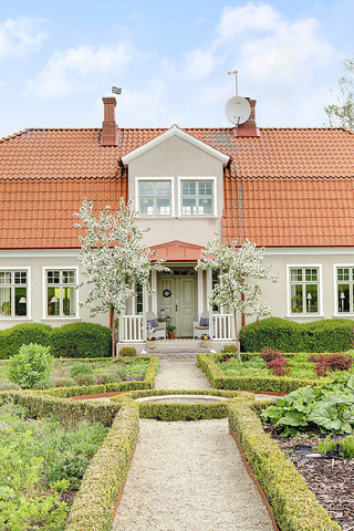 I rabatterna framför huset samsas perenner, örter, grönsaker och blommor