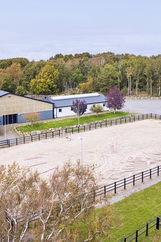 En praktiskt hinderbod är placerad mellan paddock och ridhus