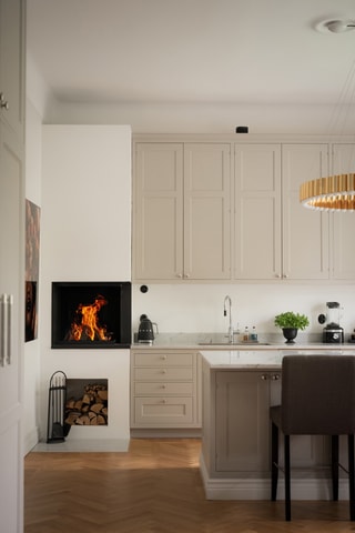 I kökets ena hörn finns en formren eldstad där brasan kan knastra