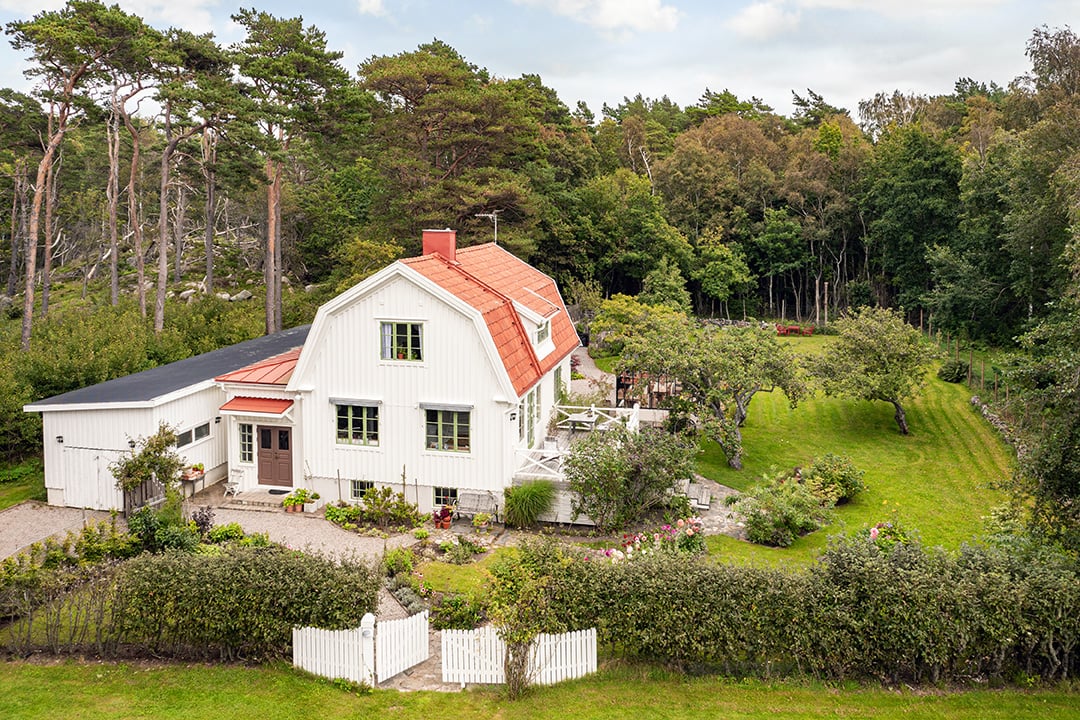 vit villa i grönskande trädgård
